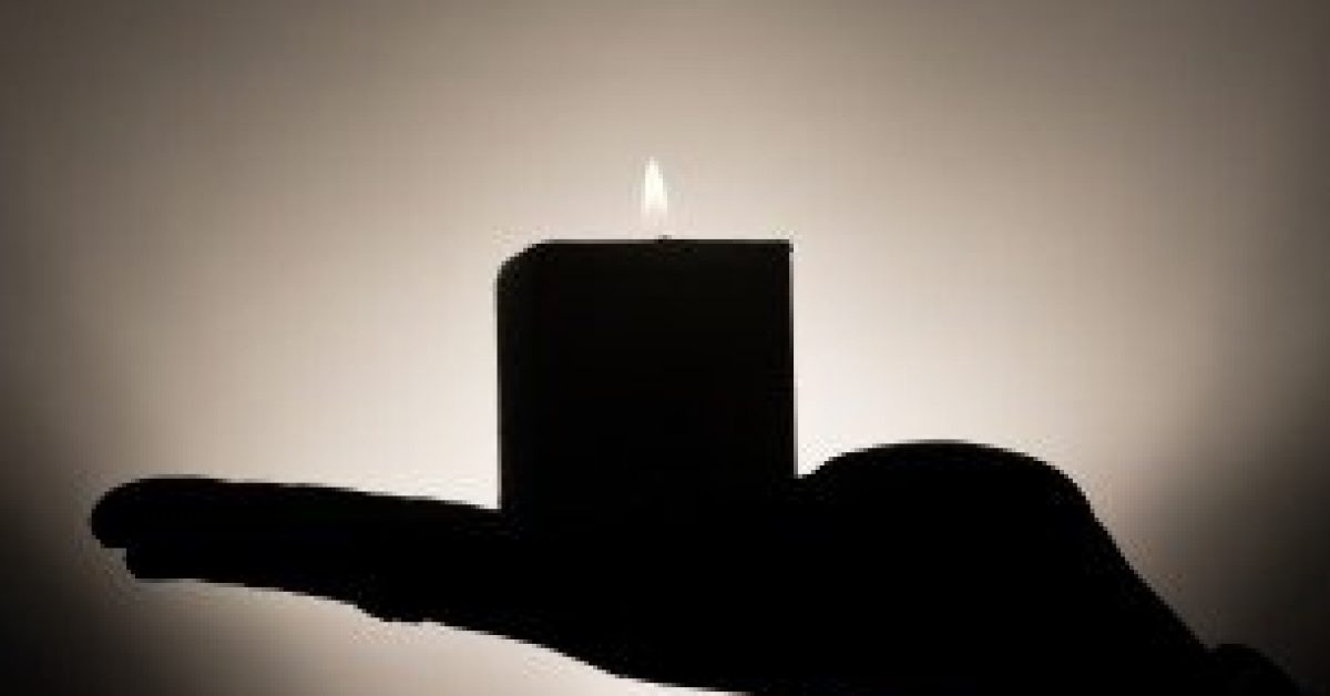 silhouette-of-human-hand-holding-candle-bw