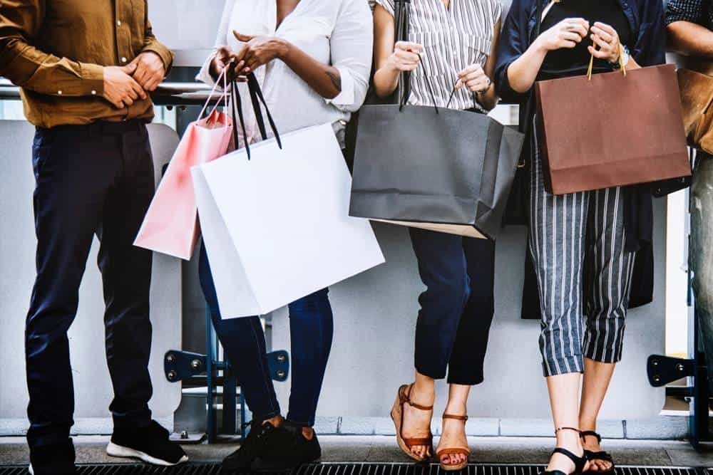 People shopping with shopping bags at a retail store or mall, showcasing retail shopping experience and consumer lifestyle.