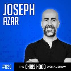 Chris Hood, digital show host with a shaved head and beard, smiling confidently against a blue background, promoting SEO-focused digital marketing and podcasting strategies.