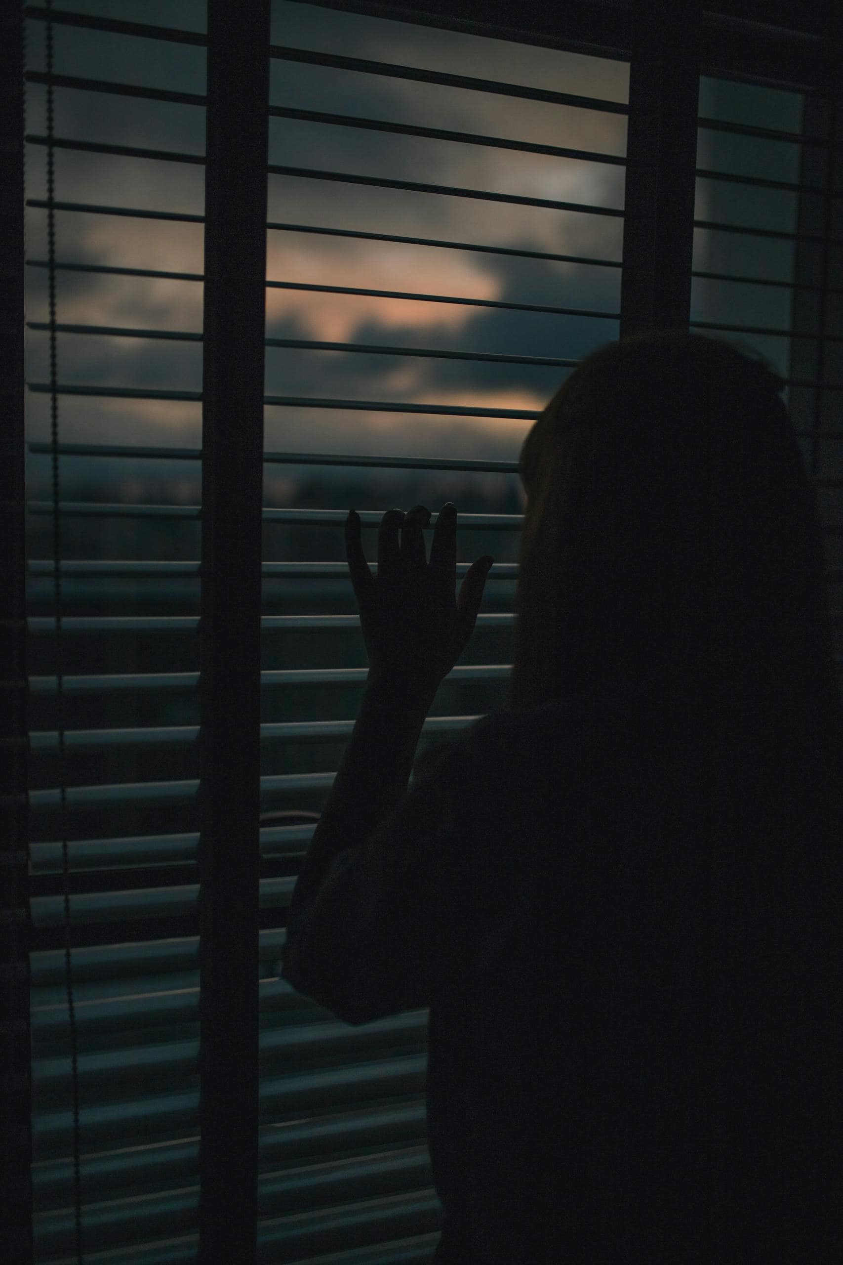 What does anxious mean? A person looking out of a window introspectively.