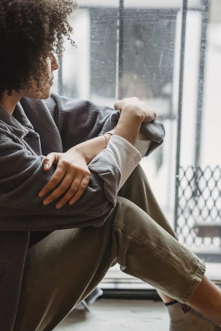 Calm reflective portrait of a person sitting alone, symbolizing emotional trauma symptoms and inner healing