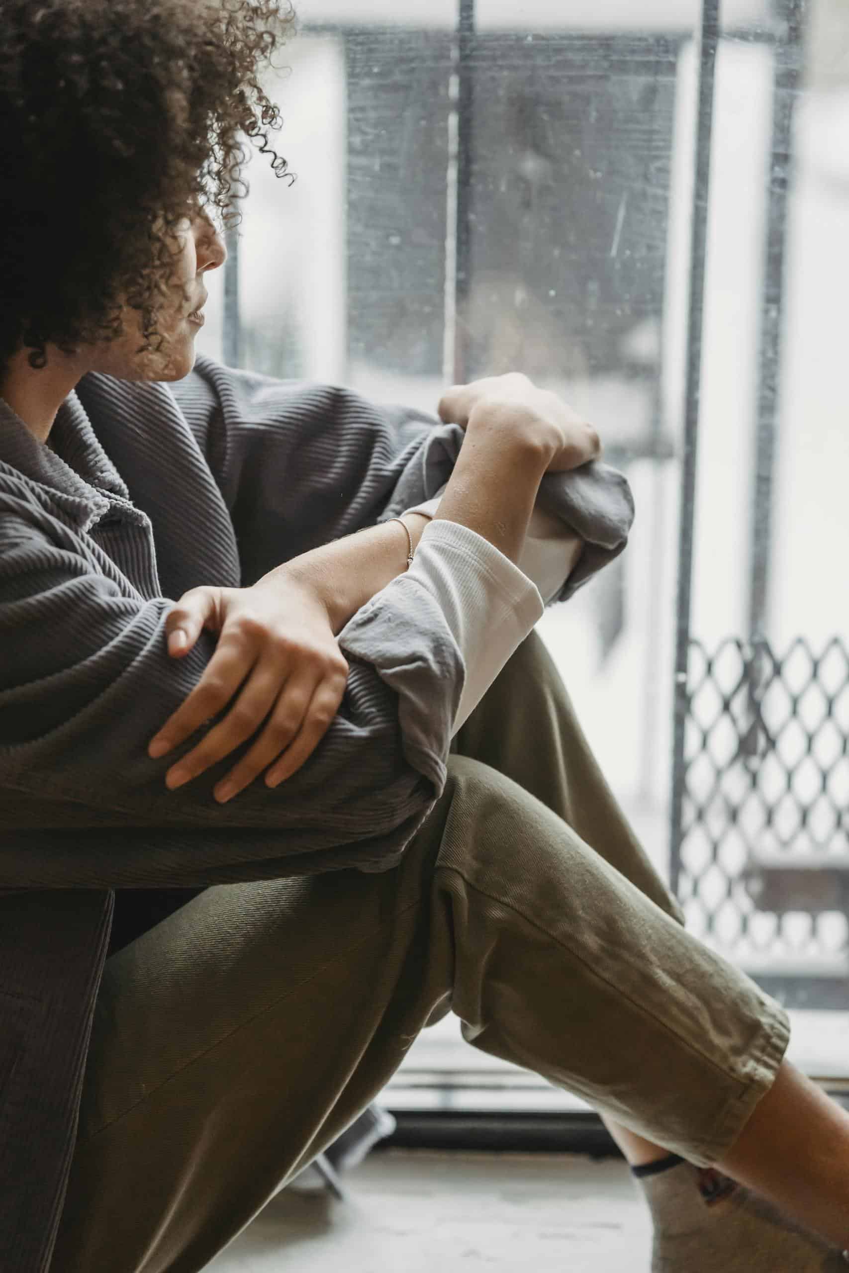 Calm reflective portrait of a person sitting alone, symbolizing emotional trauma symptoms and inner healing