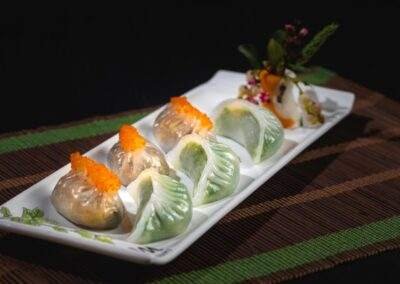 A white plate with dumplings on it.
