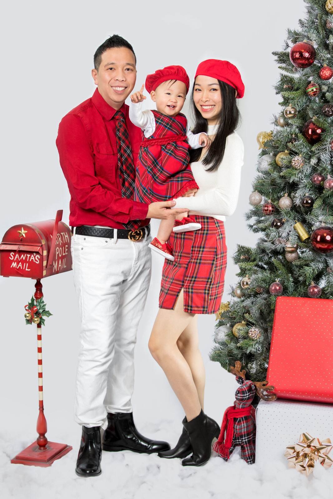 A family posing in front of a christmas tree.