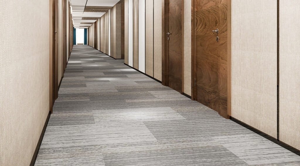 Corridor with wooden doors and modern carpet flooring in an office building.