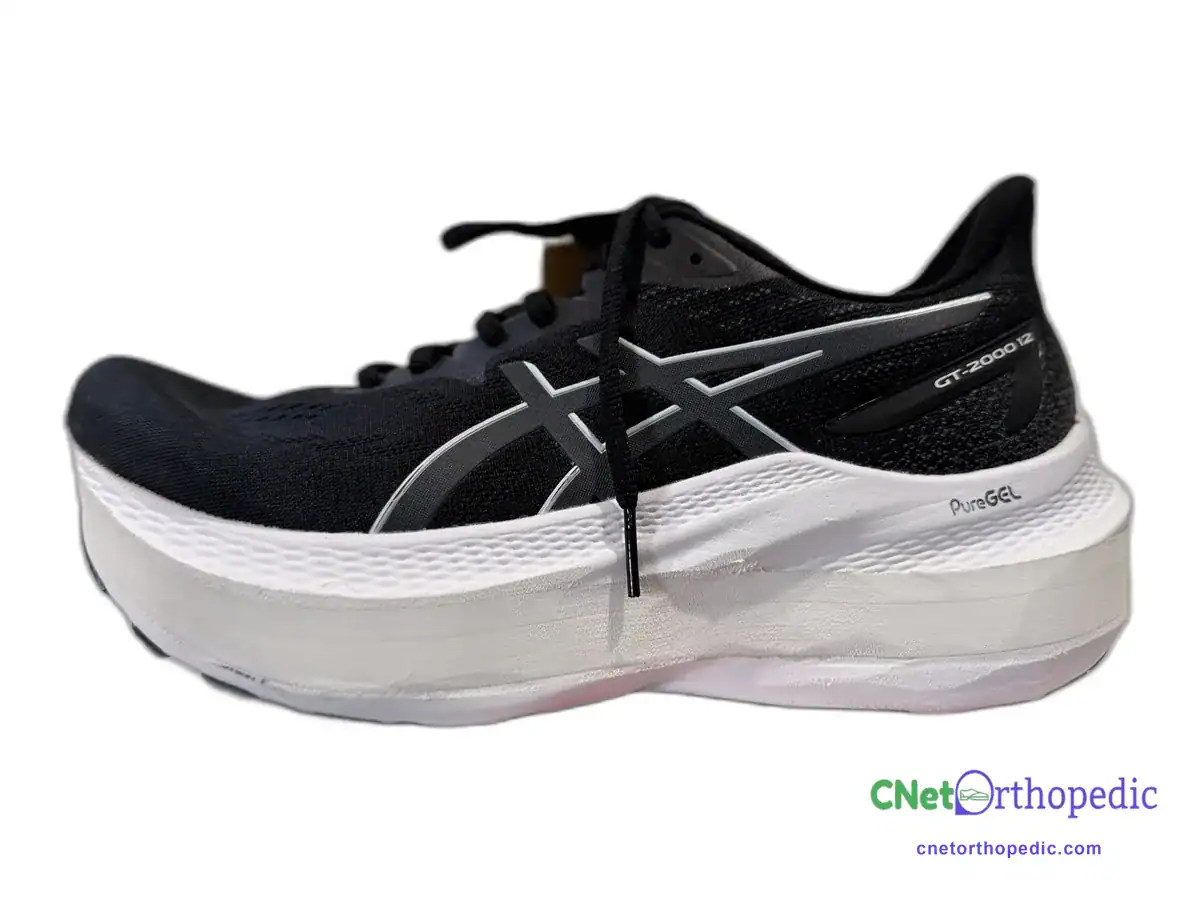 Black ASICS running shoe with a 1 inch shoe lift in the white midsole