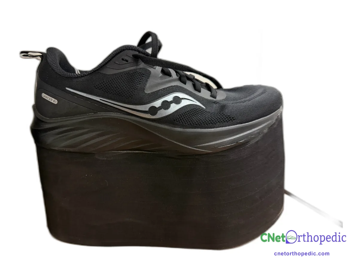Black Saucony sneaker with a 4 inch black shoe lift built under the sole