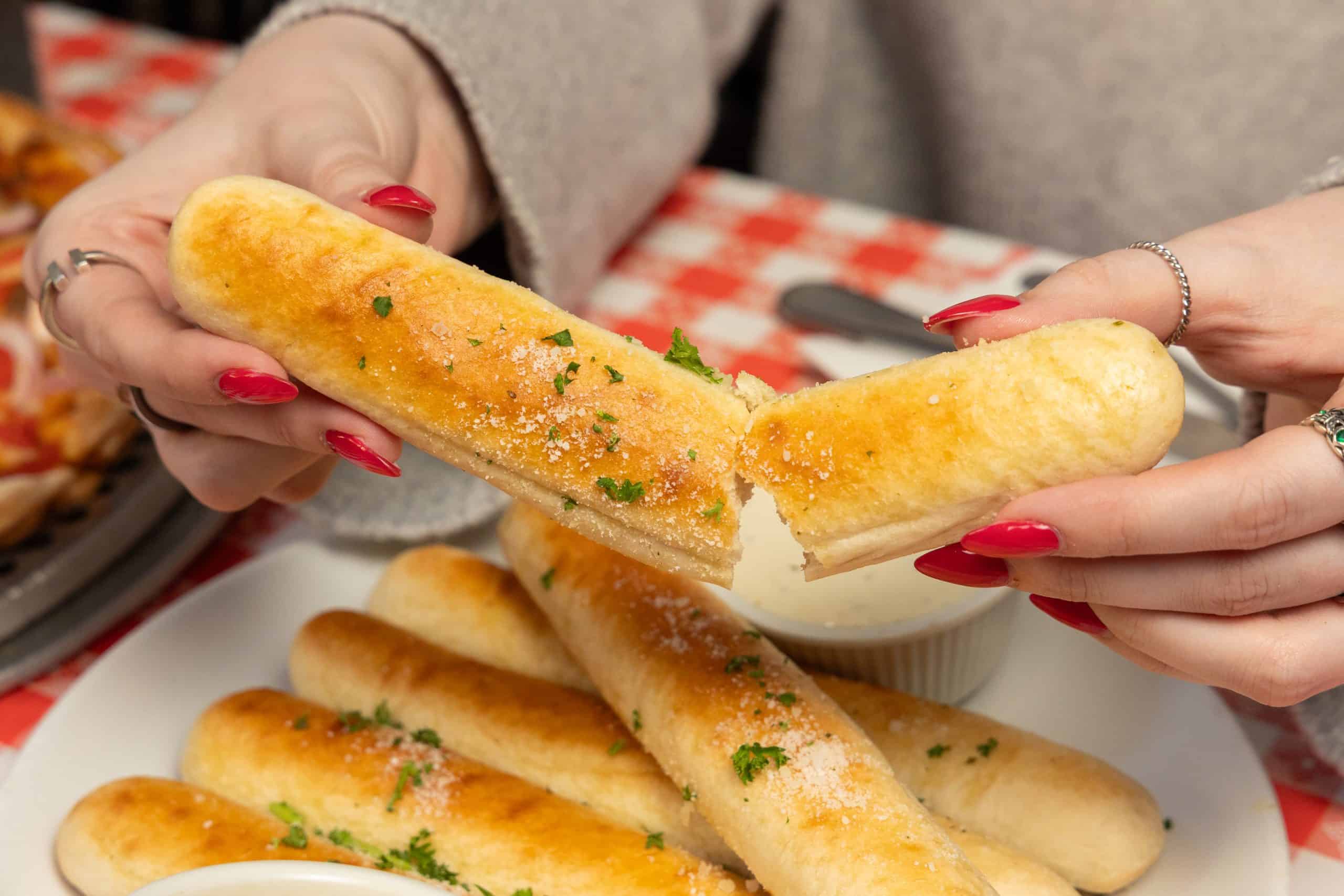 Garlic breadsticks with parsley and dipping sauce at The Comedy Bar