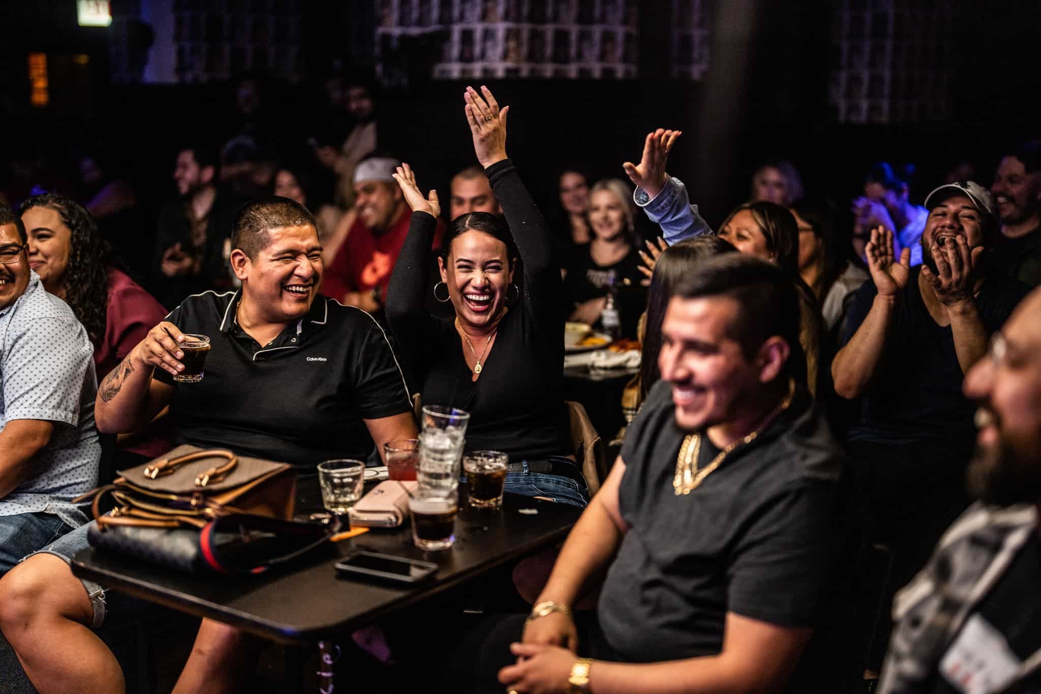 Audience laughing and cheering at a live comedy show at The Comedy Bar