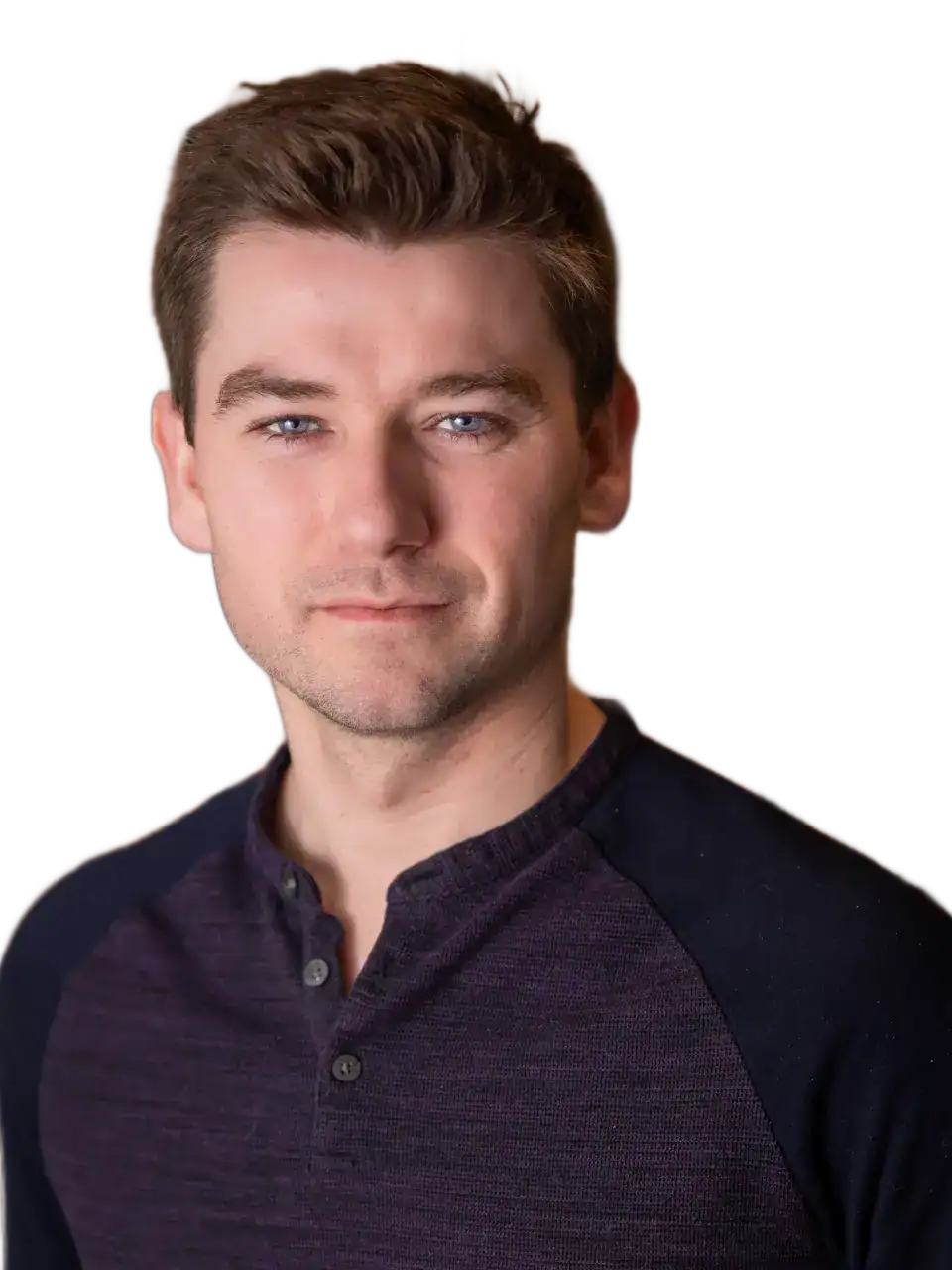 Portrait of a young man with brown hair and blue eyes, smiling confidently.