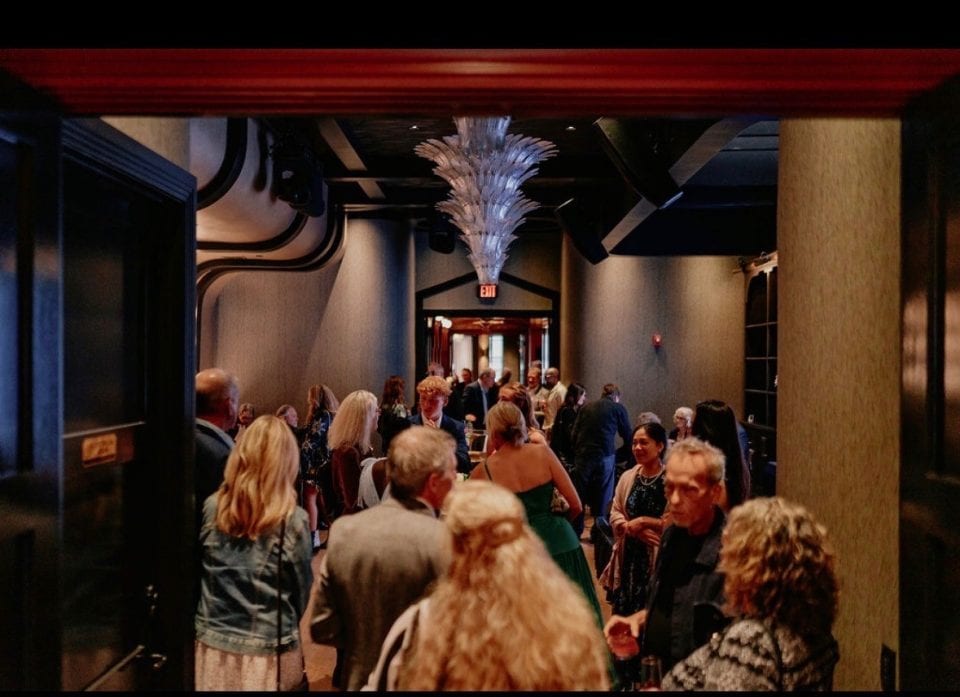 Crowd of people at a networking event in a stylish venue with modern decor.