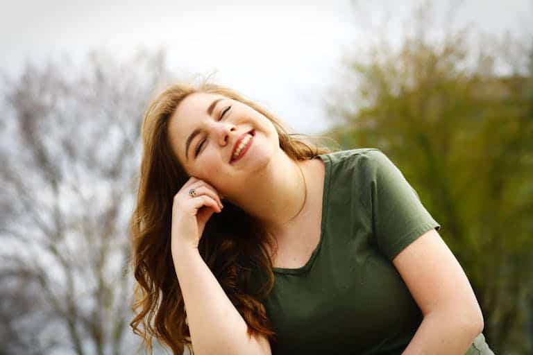A carefree woman enjoying a sunny day outdoors, expressing pure happiness and relaxation.