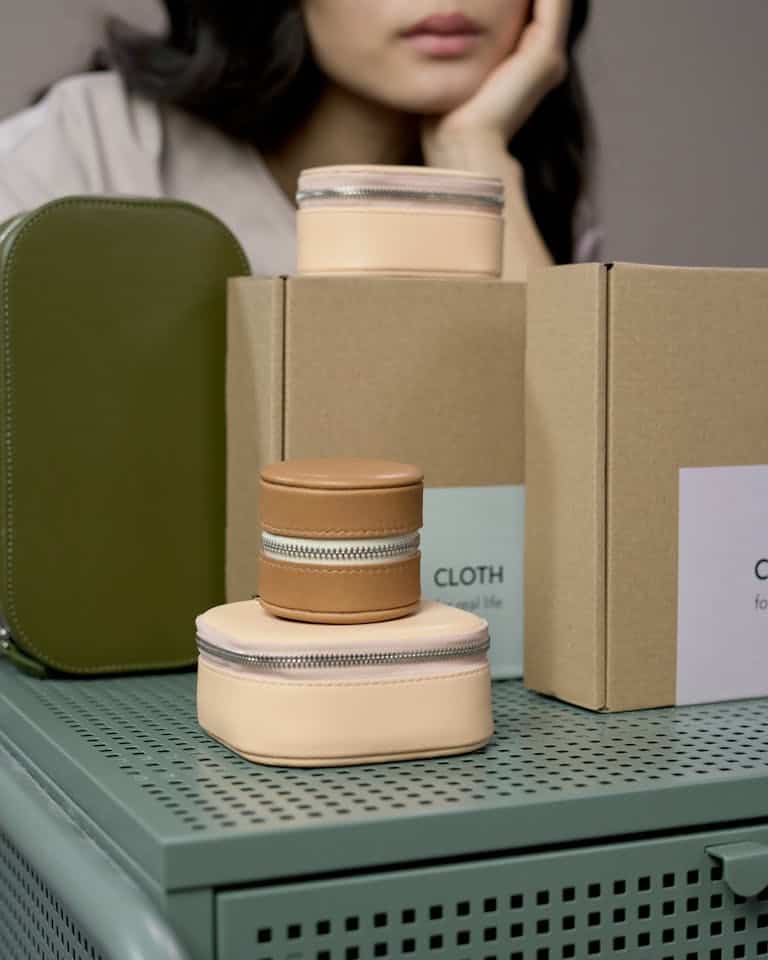 Stylish bags and packaging displayed in a minimalist studio with an elegant touch.