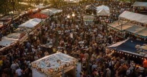 Crowds enjoying food festivals around the world at a colorful outdoor street market at golden hour.