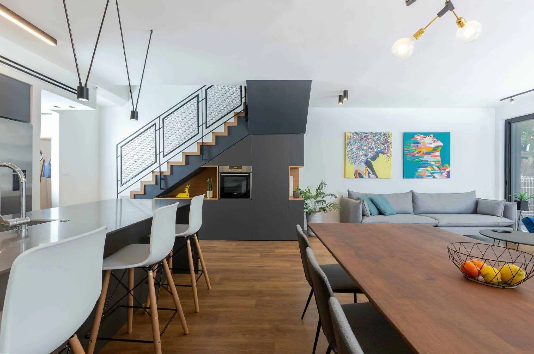 Modern open-plan living space with kitchen island, dining table, and living room.