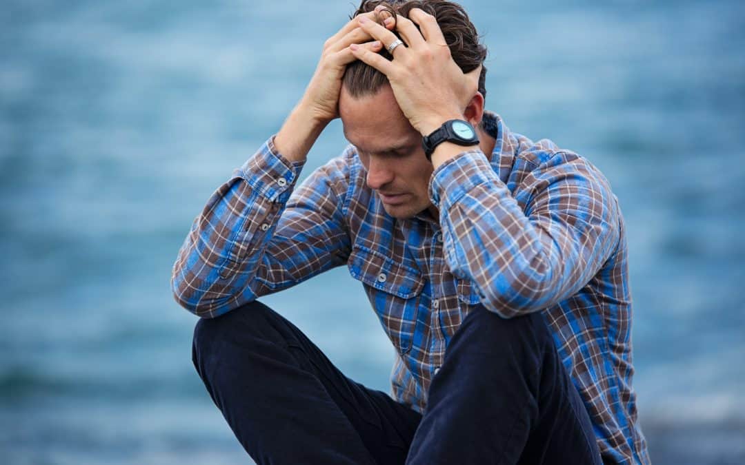 Frustrated man holding his head in his hands