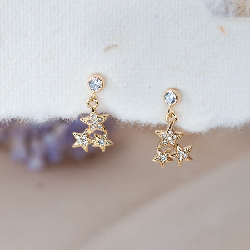 Gold star stud earrings with delicate sparkle
