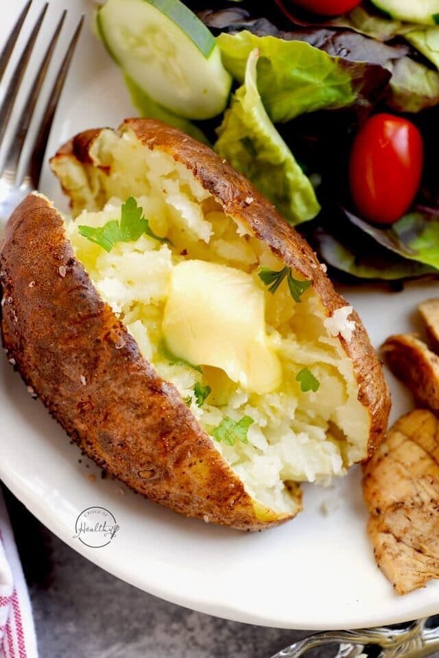Crispy-skinned baked potatoes split open with toppings