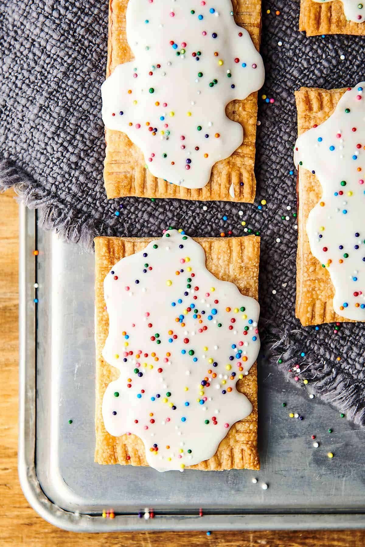 Glazed strawberry pop-tarts with sprinkles on a tray