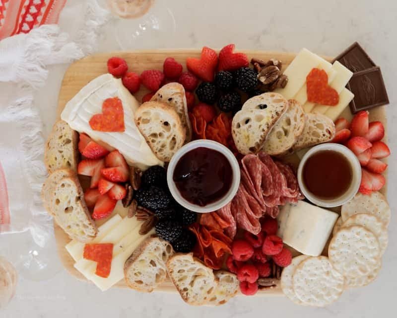 Romantic charcuterie board for two with cheeses, cured meats and fruit