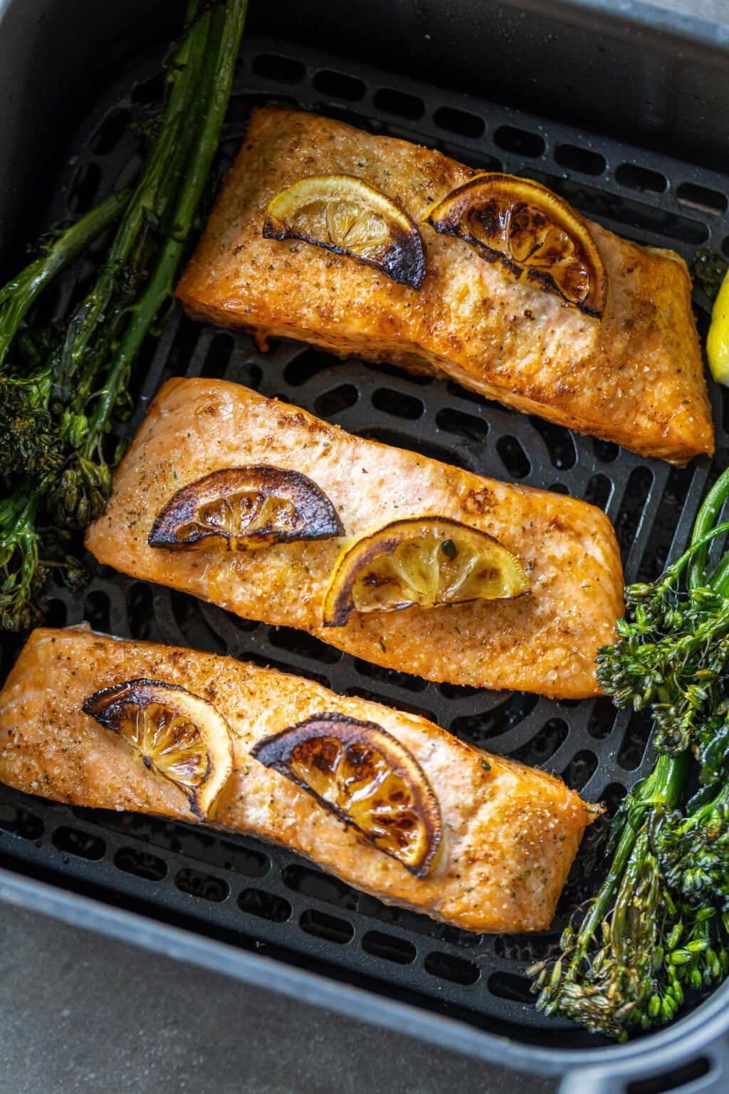 Crispy-skinned air fryer salmon fillet on a plate with herbs