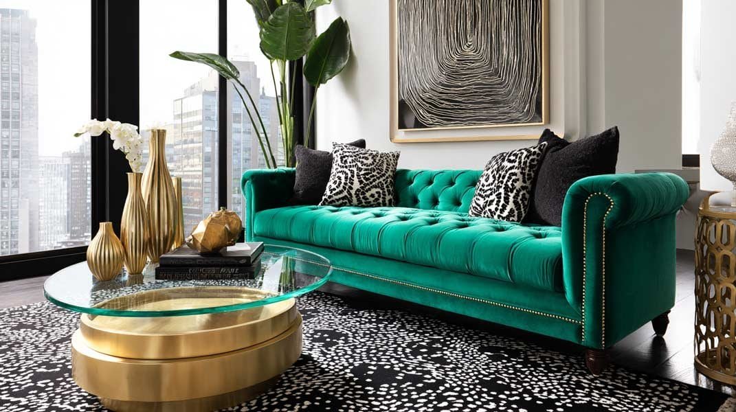Luxury small living room with emerald green velvet sofa, brass glass coffee table, and modern art.