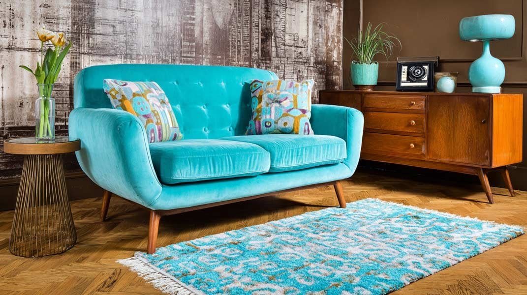 Vintage-inspired living room with a mid-century turquoise loveseat, wood credenza, and patterned rug.