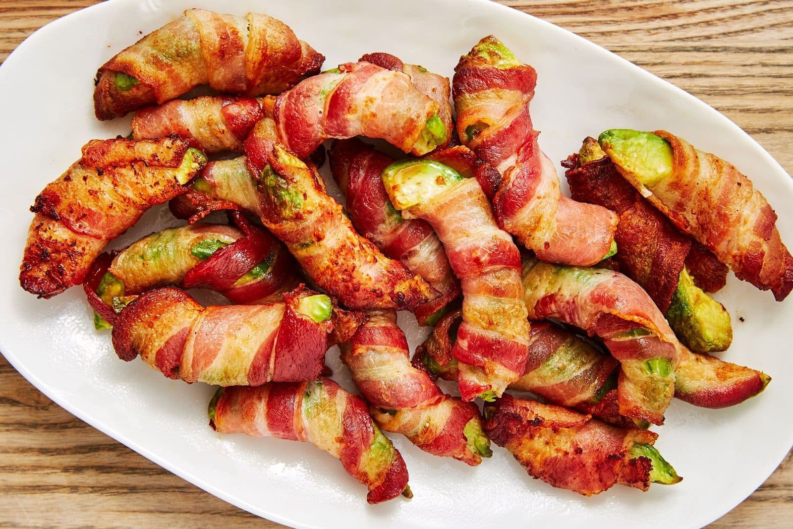 Bacon-wrapped avocado fries served with dipping sauce