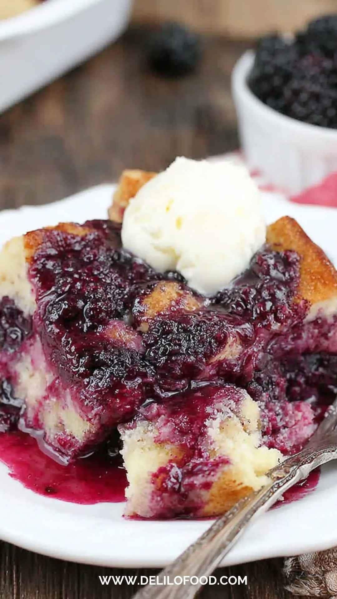 Cozy blackberry bread pudding served warm with a scoop of vanilla ice cream and sweet blackberry sauce on top