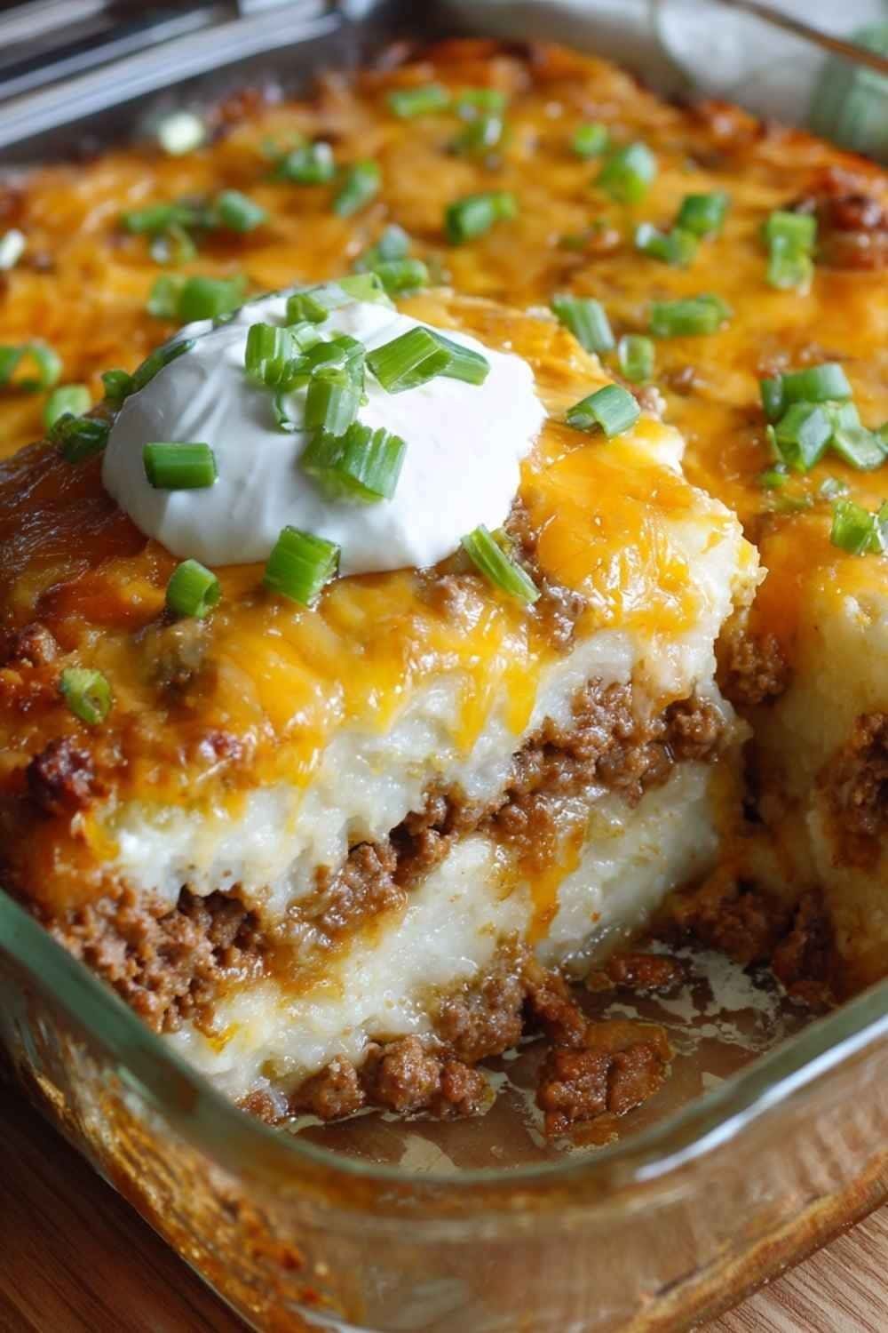 Loaded Potato and Meatloaf Casserole baked in a glass dish topped with melted cheddar cheese and crispy bacon
