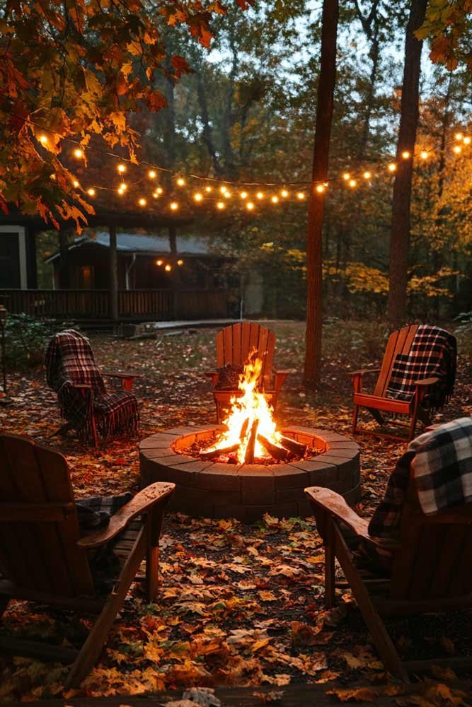 Rustic backyard fire pit surrounded by wooden chairs and string lights