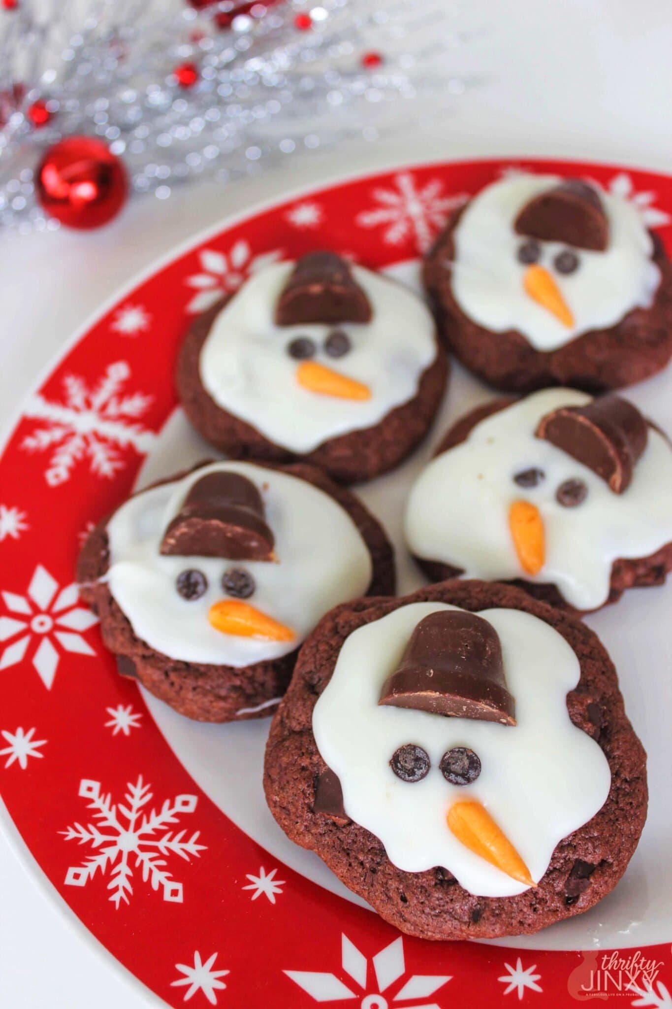Melting snowman cookies decorated with marshmallow heads and icing