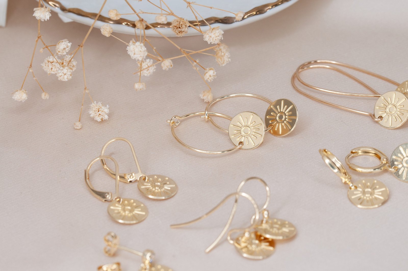 Multiple sun disc earrings in different styles lined up together for styling inspiration