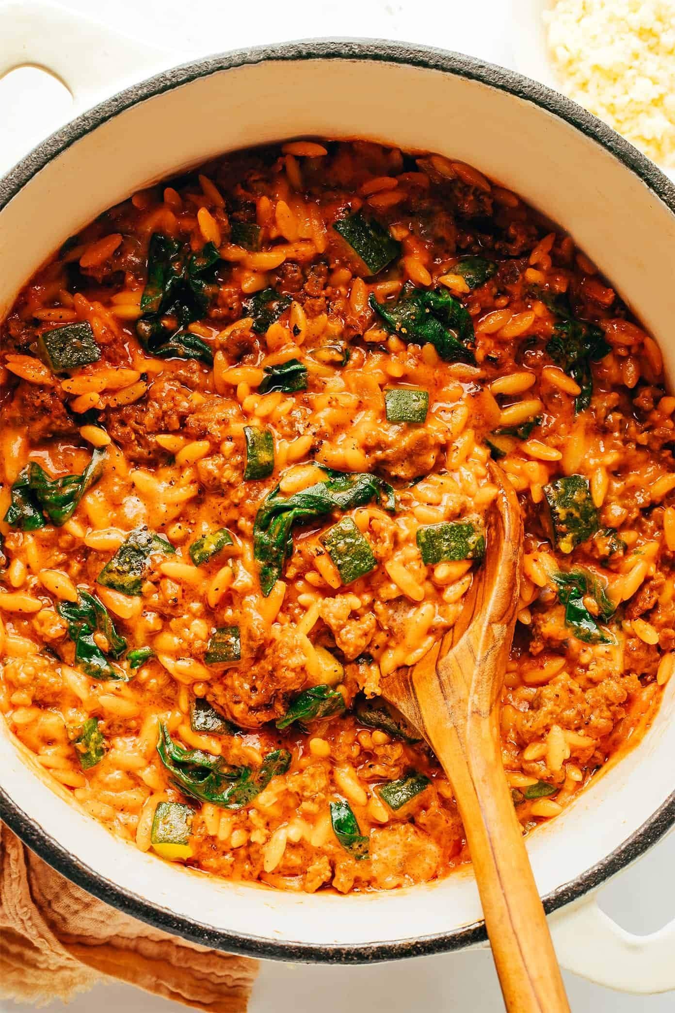 Italian sausage orzo pasta with vegetables in a skillet