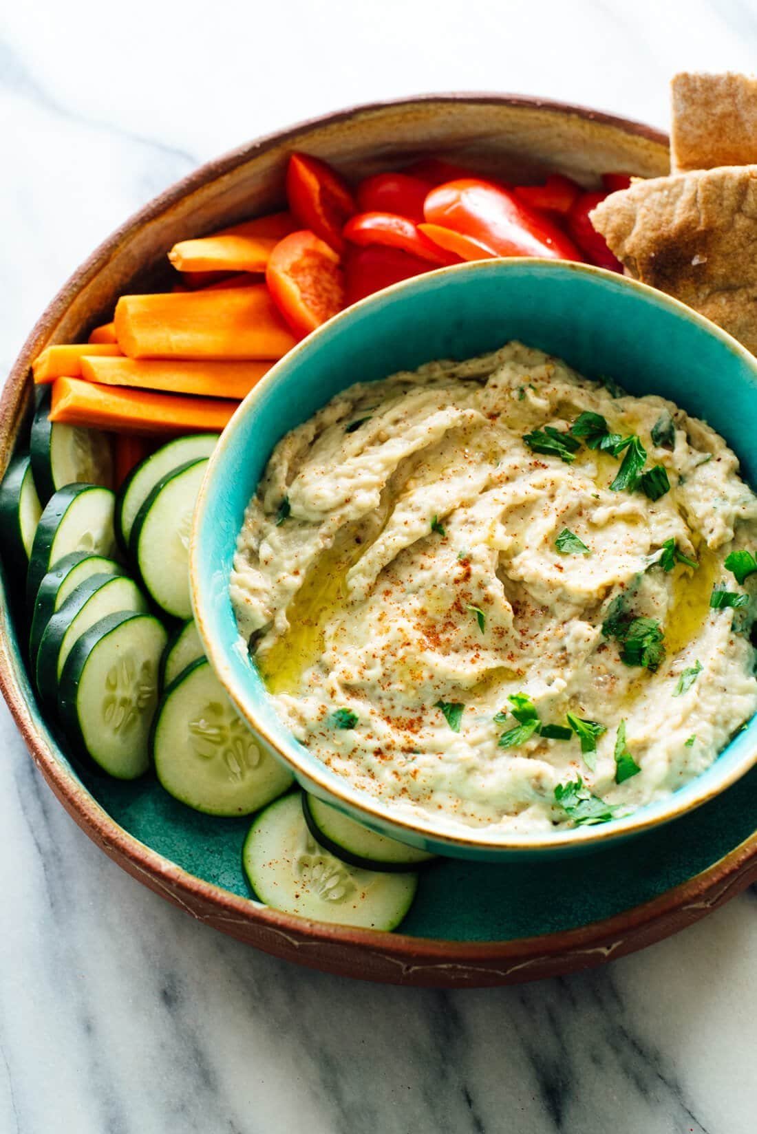 Smoky baba ganoush served in a bowl with pita and vegetables.