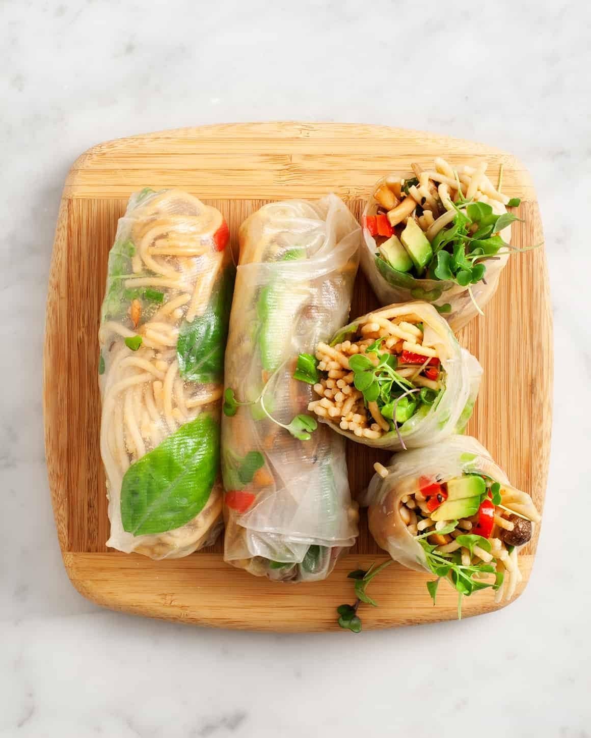 Fresh vegan spring rolls filled with colorful vegetables and served with dipping sauce.