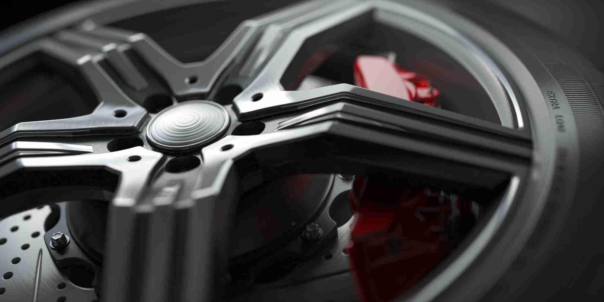 Alloy car wheel with disk brakes close up background.