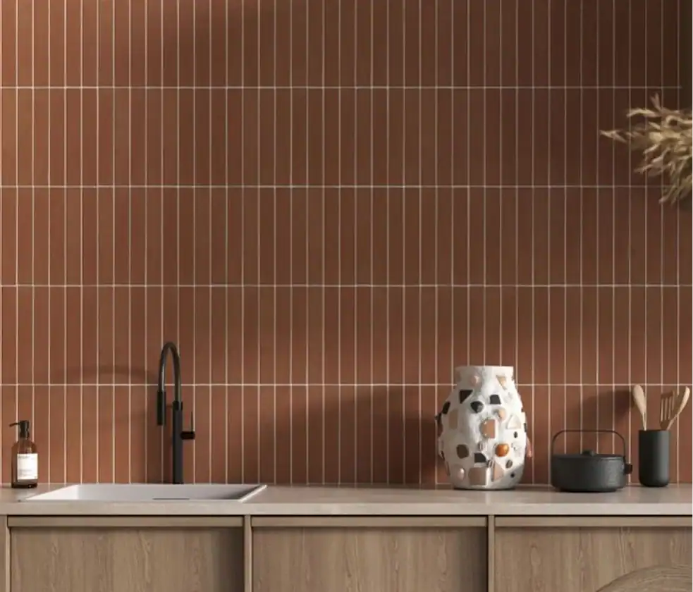 Modern kitchen with vertical terracotta tile backsplash, matte black faucet, and light wood cabinetry