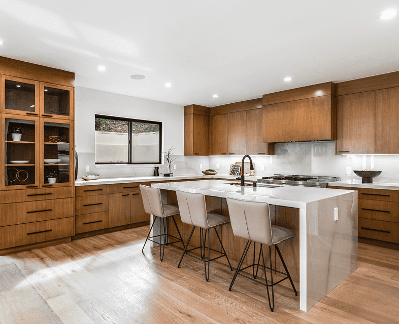 Warm contemporary kitchen with flat-panel wood cabinets, white quartz countertops, and a central island with seating