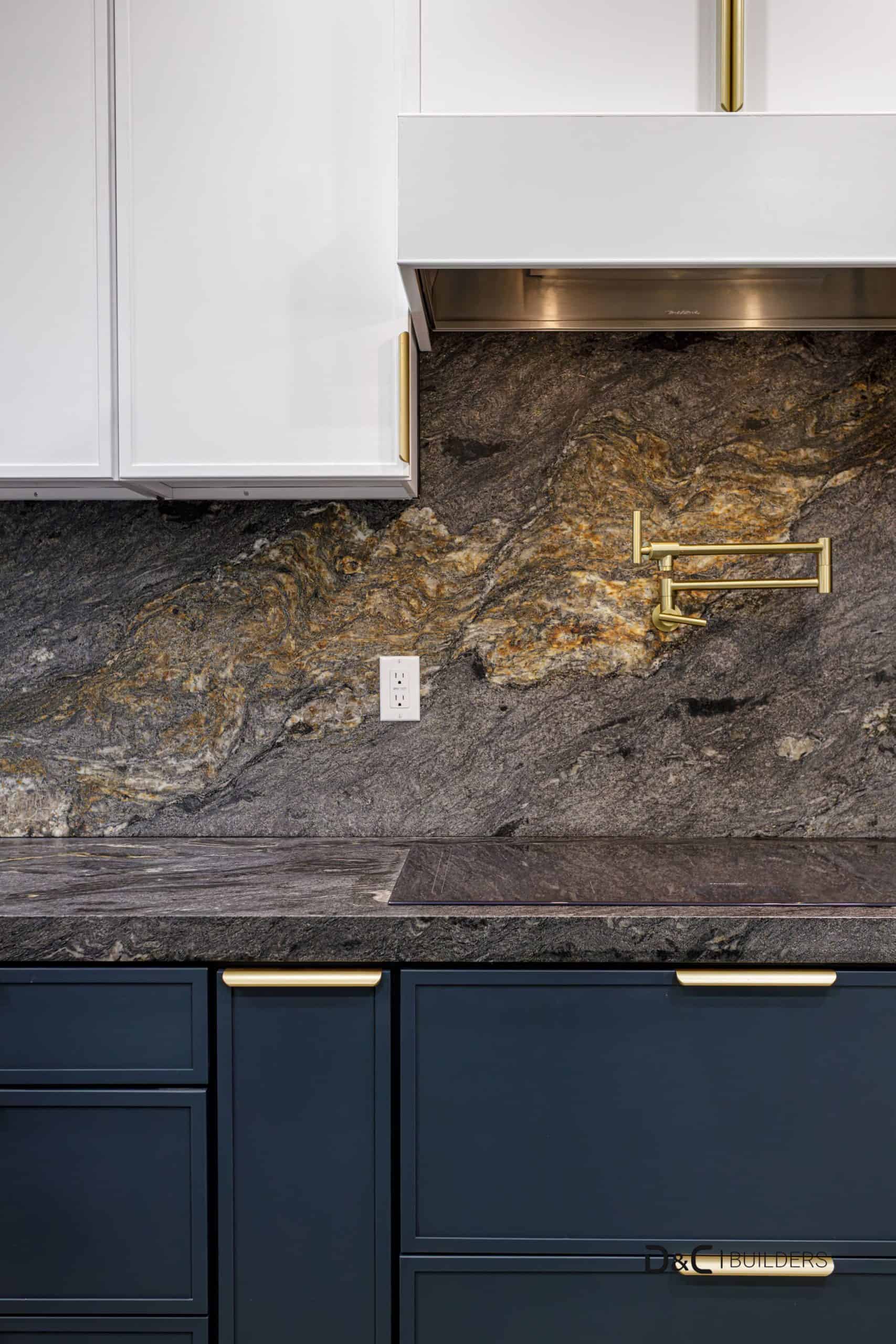 Custom kitchen remodel in New Port with navy blue cabinets, natural stone backsplash, and brushed gold hardware