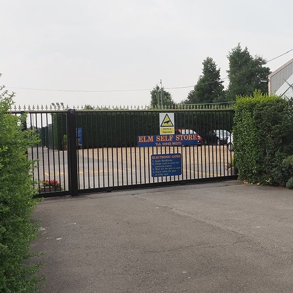 Secure storage facility gate with Elm Self Store signage and electronic gate access system.