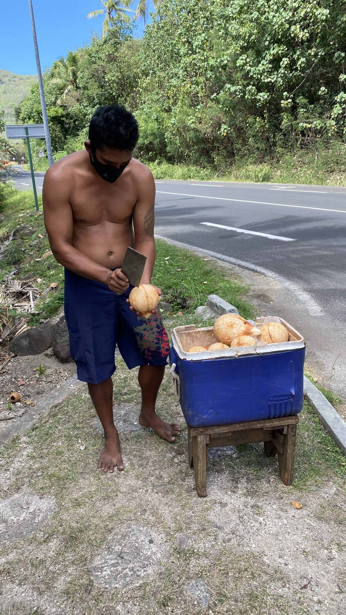 A street side vendor opening a coconut for us