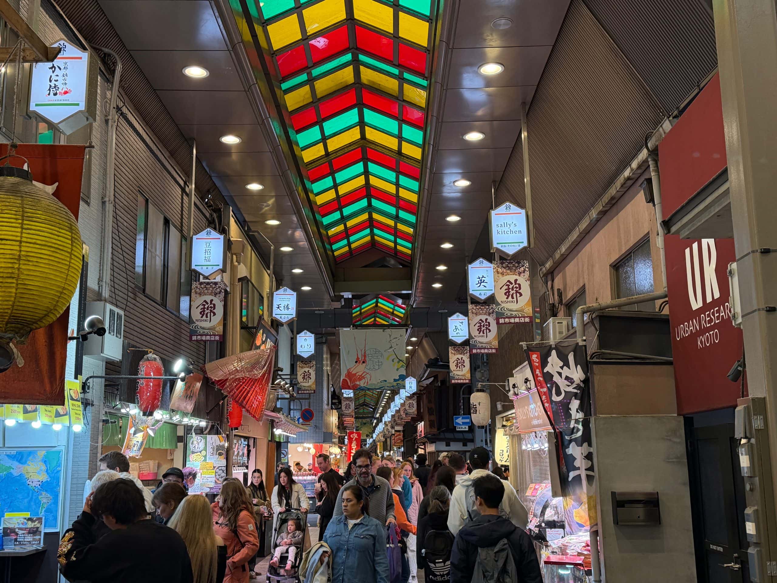 Bright colorful Asian marketplace with bustling crowd and vibrant decor.