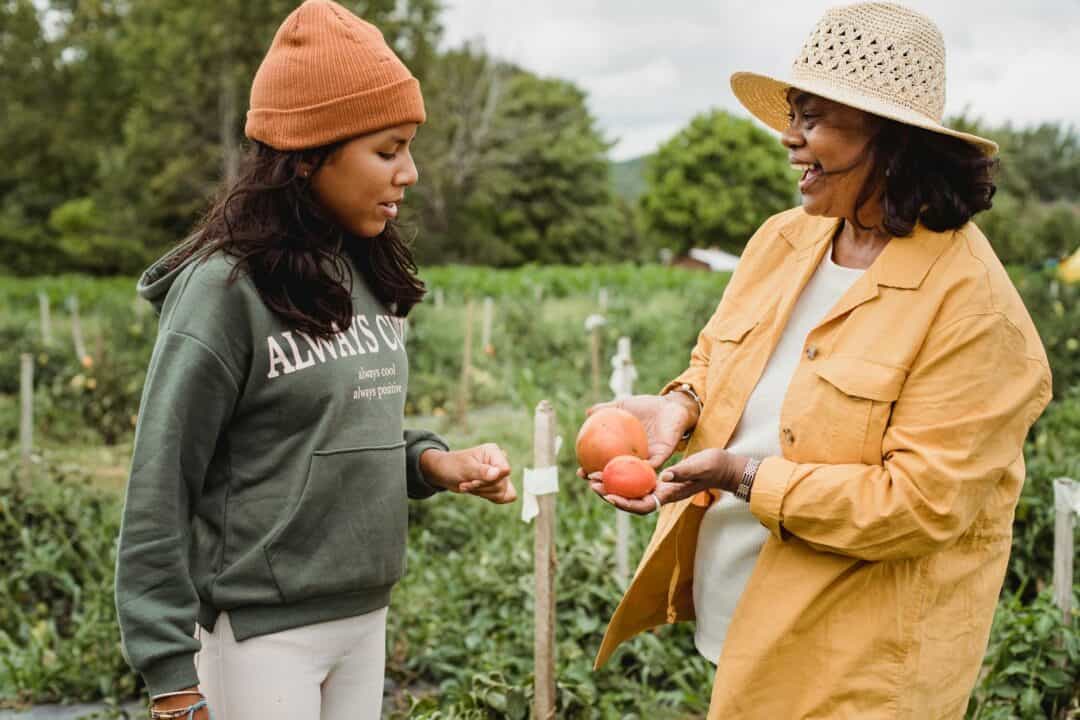 mom and teen daughter working together in the garden