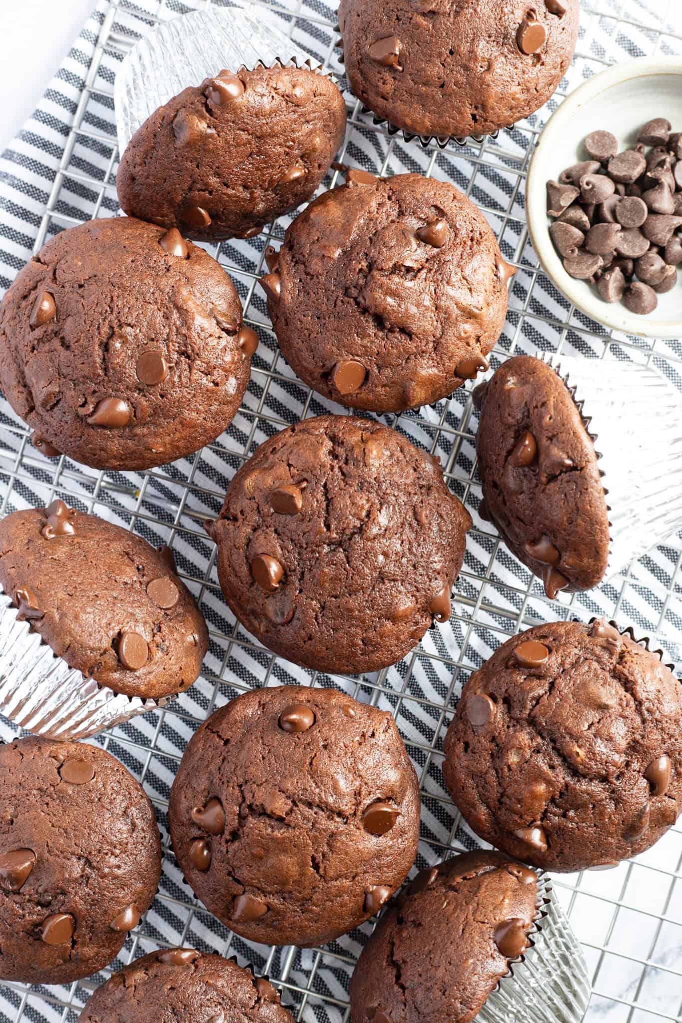 A dozen moist chocolate muffins with buttermilk arranged on a cloth napkin.