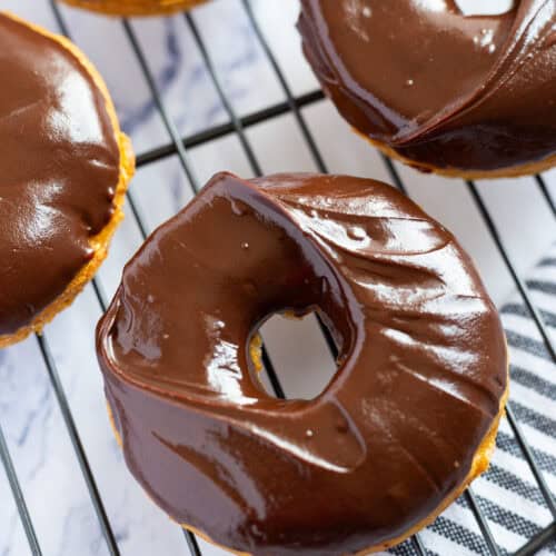 Baked pumpkin donuts filled with warm spices and topped with a chocolate glaze.