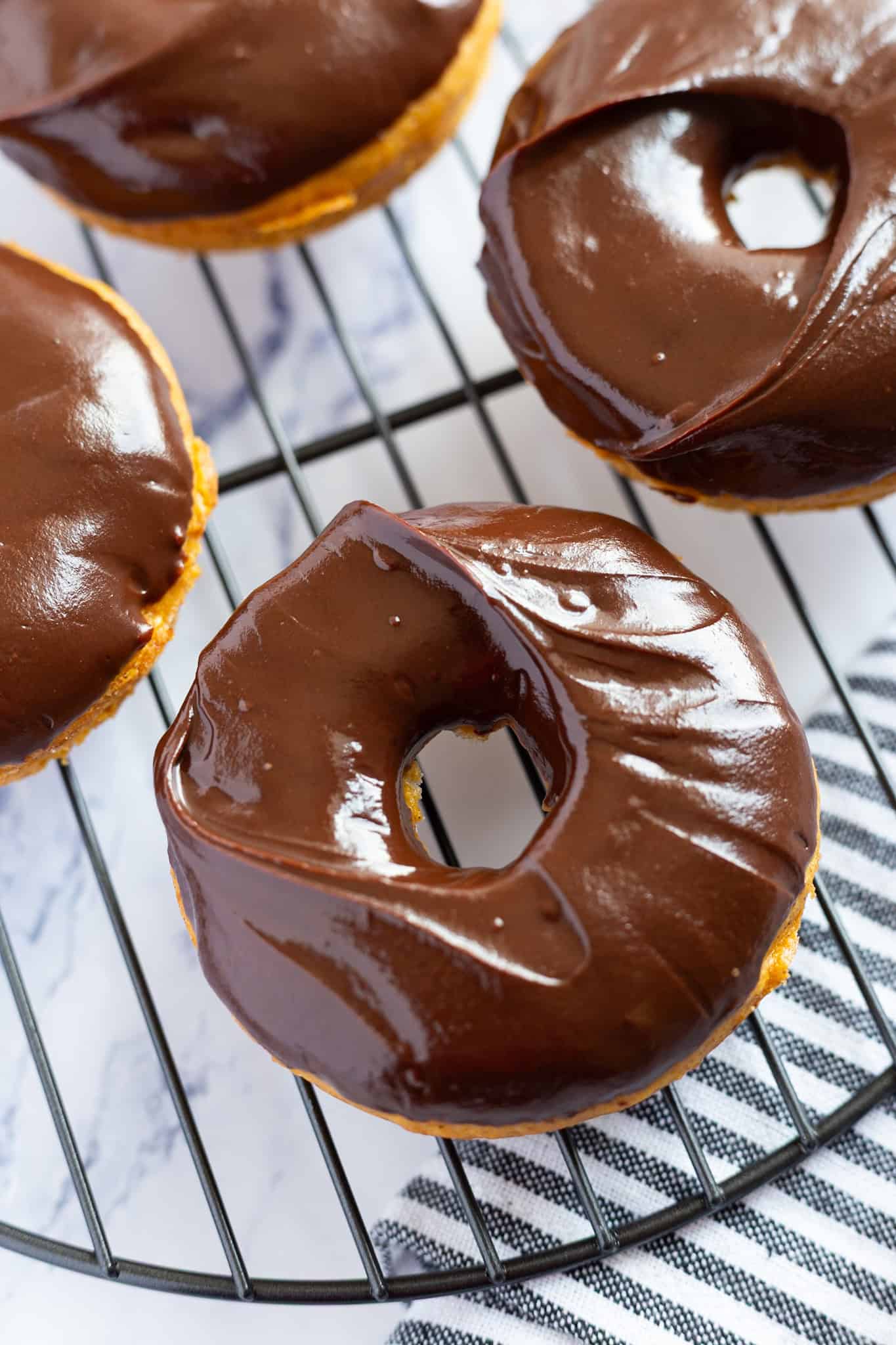 Baked pumpkin donuts filled with warm spices and topped with a chocolate glaze.