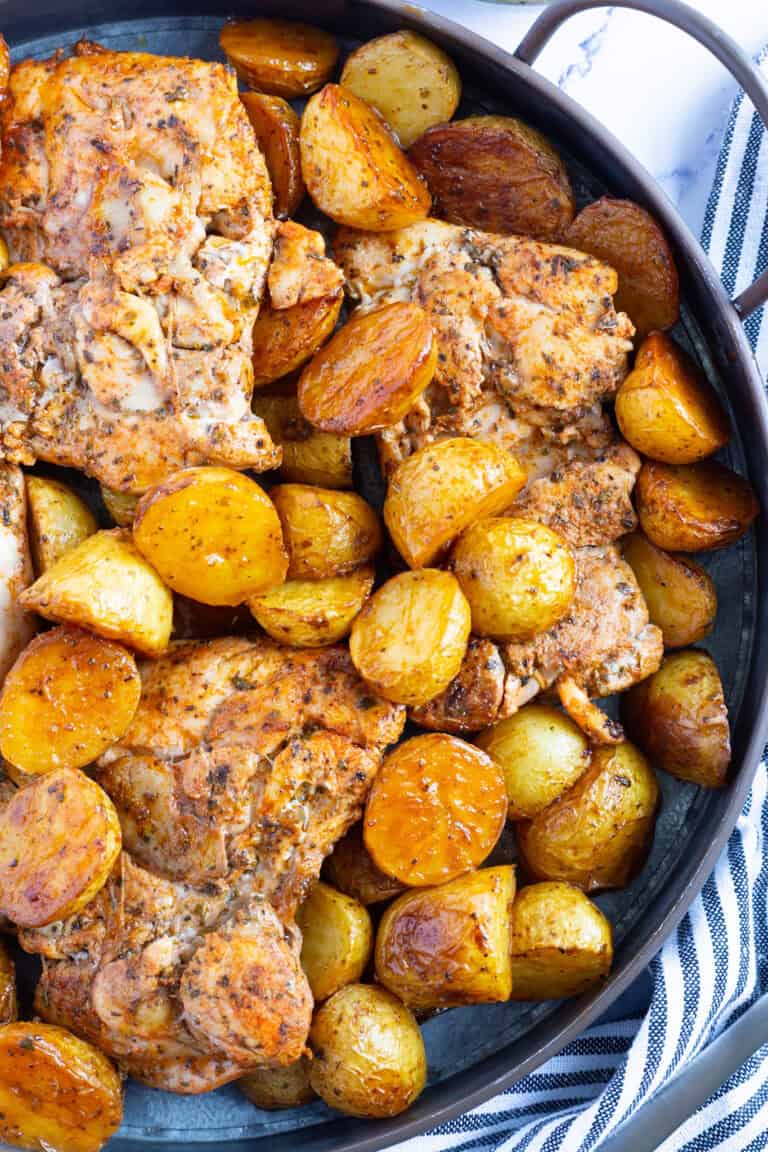 Baked chicken thighs with vinegar and potatoes.