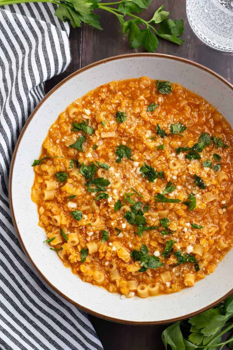 A hearty bowl of red lentil soup with pasta.