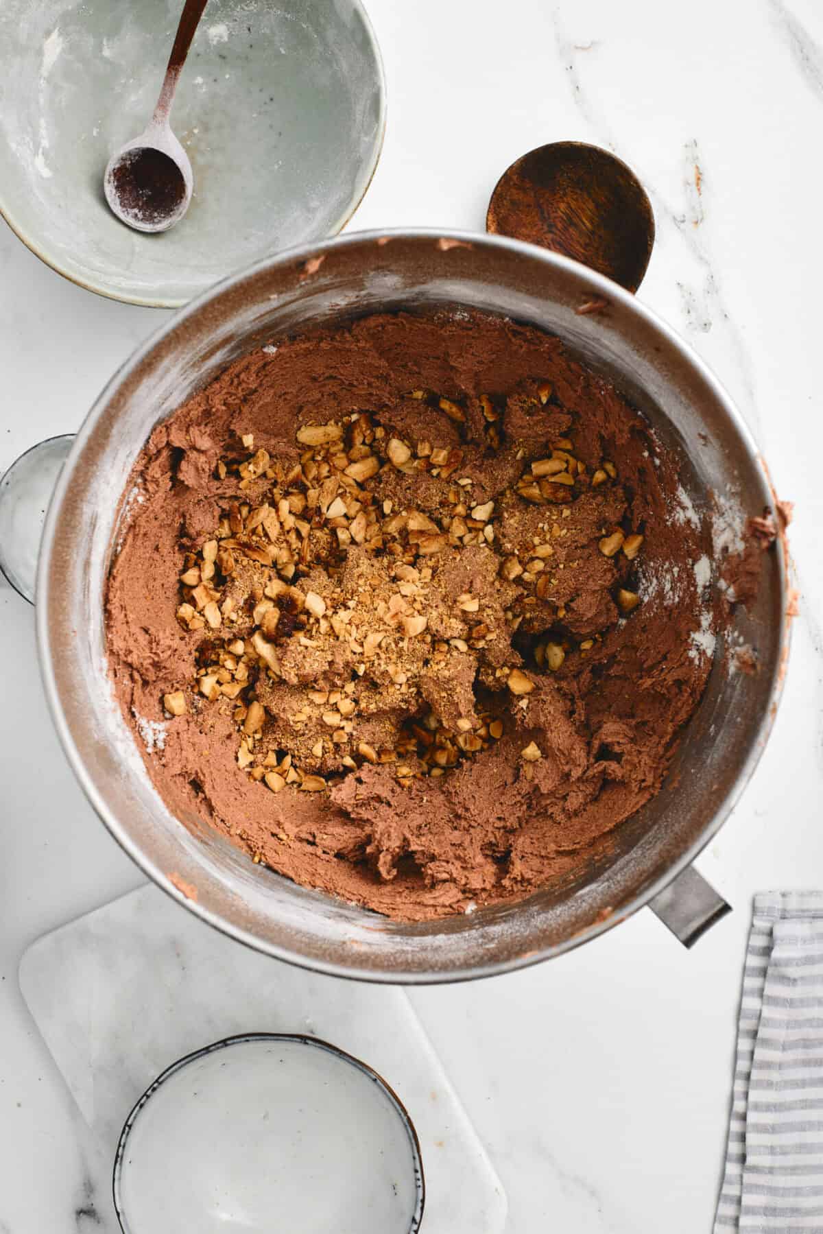 A bowl of cookie batter with almonds.